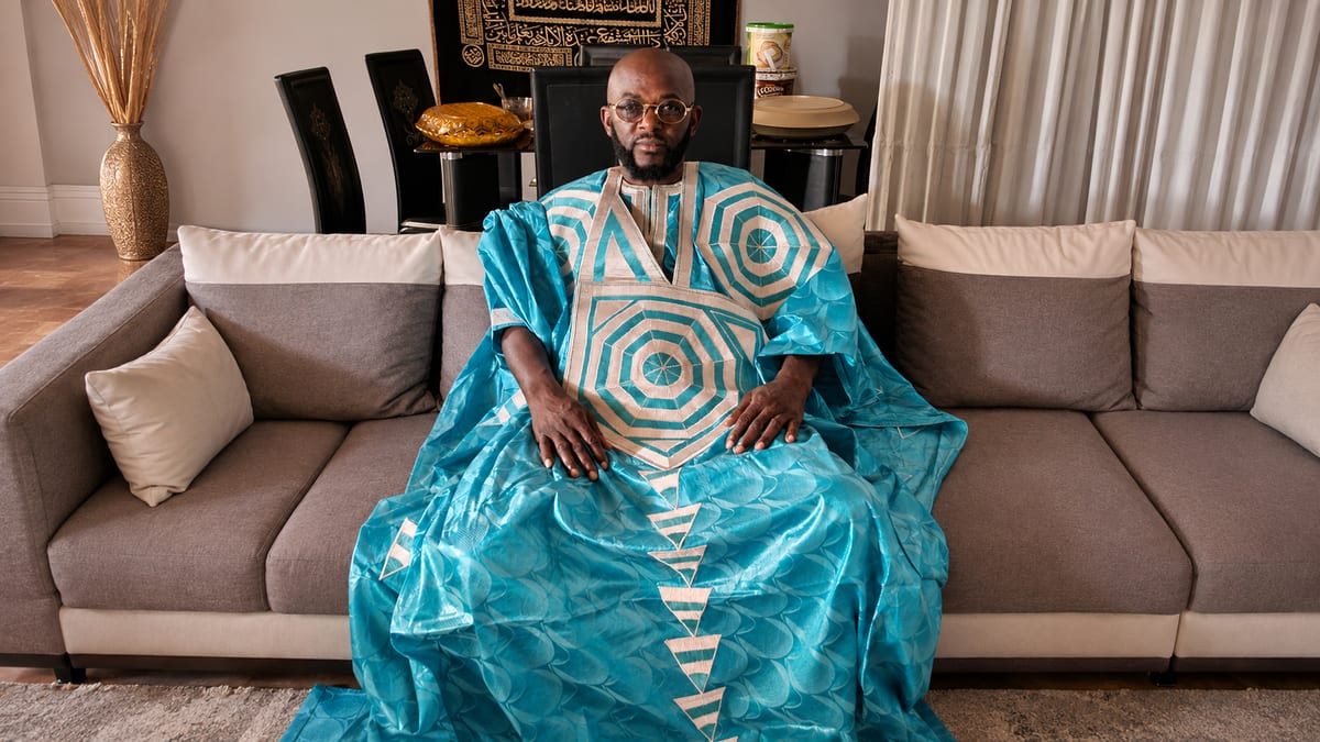 Marabout Djibril in boubou turchese, seduto nel suo salotto