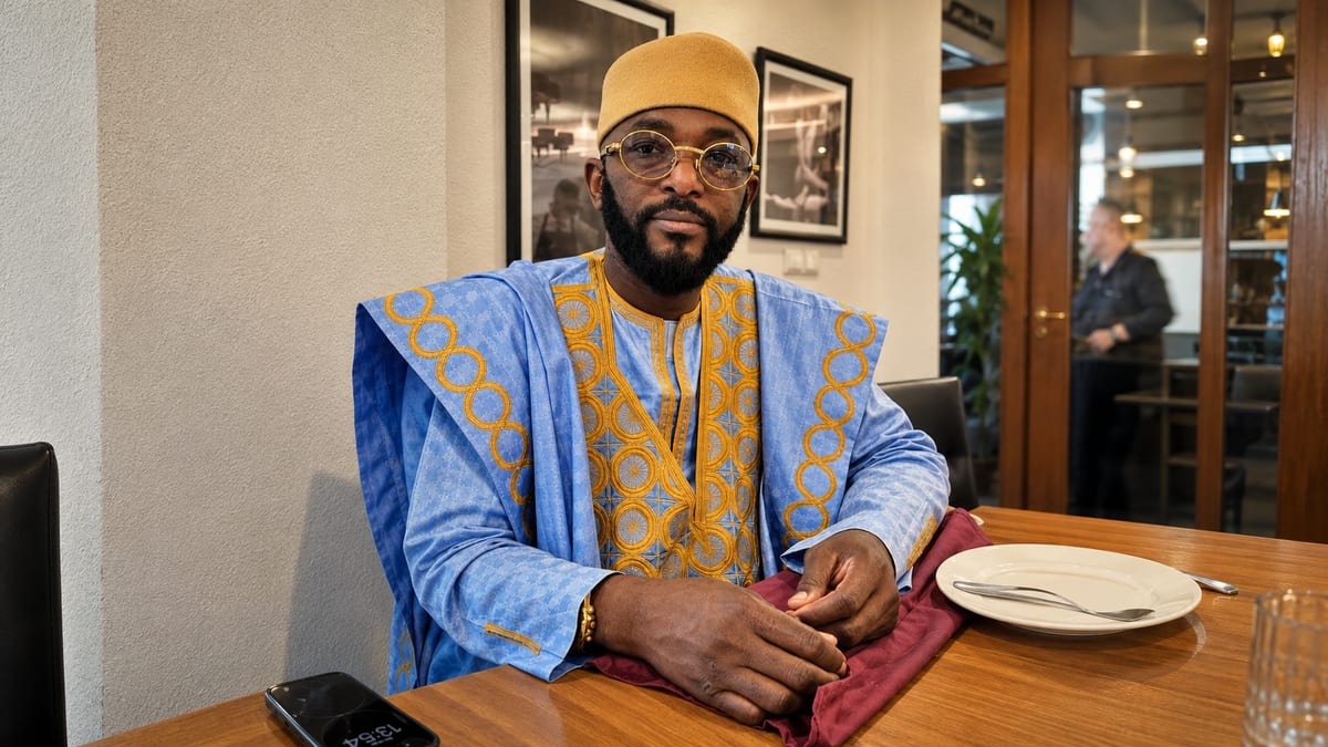 Marabout Djibril in boubou blu e oro, seduto durante un consulto